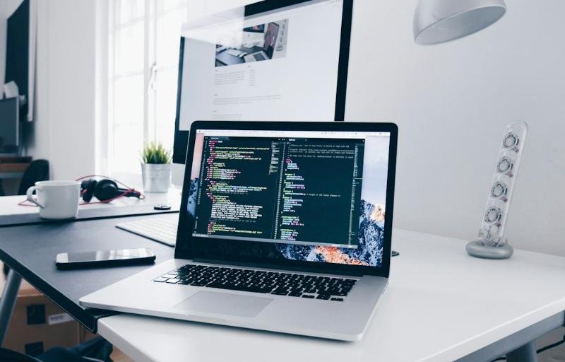 Laptop on a tidy desk with code on screen